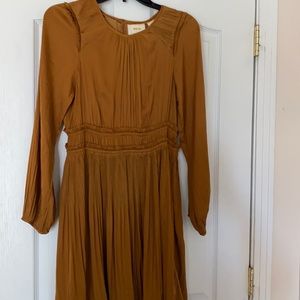 Gold silk dress with ruching details.